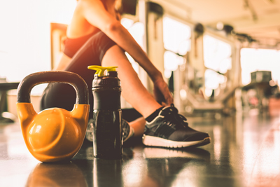 young woman in gym with kettlebell and water bottle